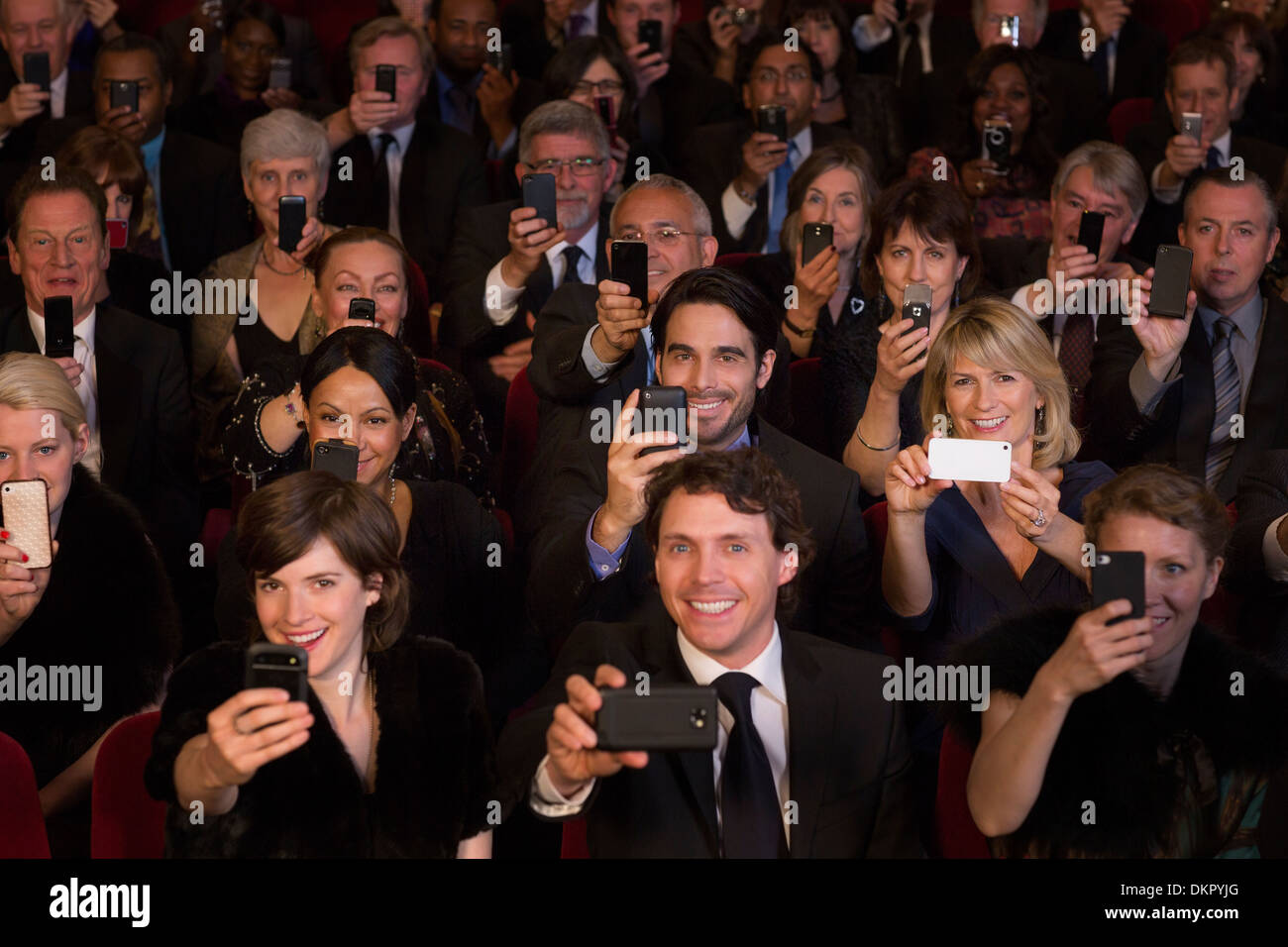 Il pubblico del teatro di filmare le prestazioni con i telefoni intelligenti Foto Stock