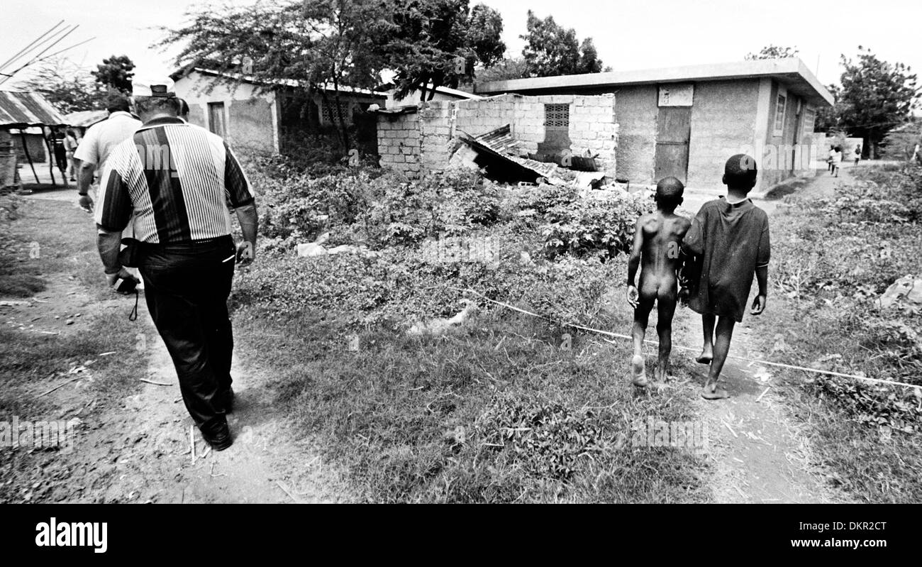Nov. 19, 2002 - Port-Au-Prince, Haiti - nonostante tutti i sorrisi e le lacrime, nonostante la comune esperienza umana, diviene ovvio alla fine di un viaggio che i donatori e i beneficiari degli aiuti sono ancora su due percorsi divergenti. Il povero passo indietro alle loro baracche e baraccopoli, mentre il ritorno dei donatori per le loro auto e le suddivisioni, ma con i ricordi indelebili del loro vicini poveri, WH Foto Stock