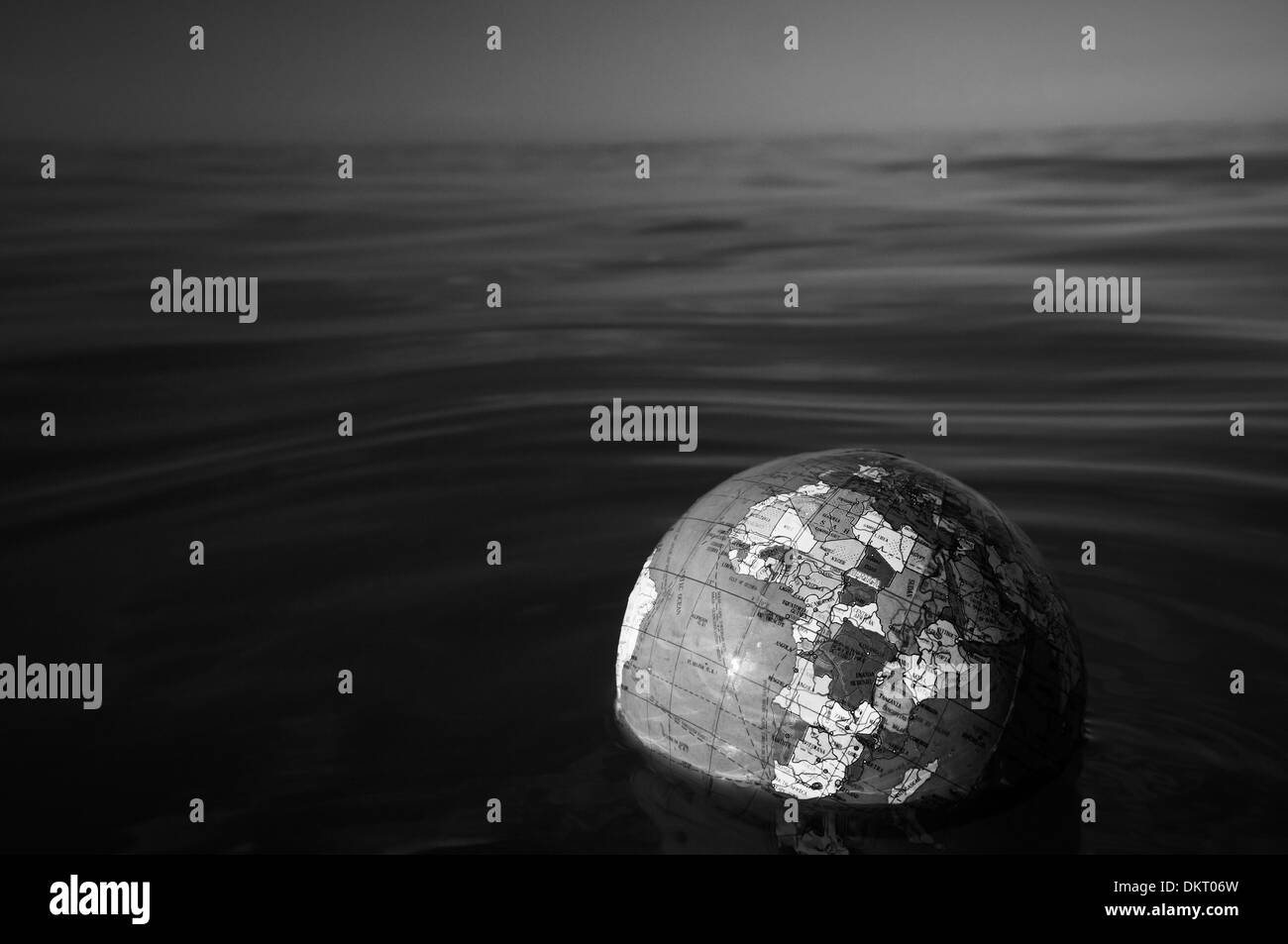 Mondo globo di plastica galleggianti in acqua di mare Foto Stock