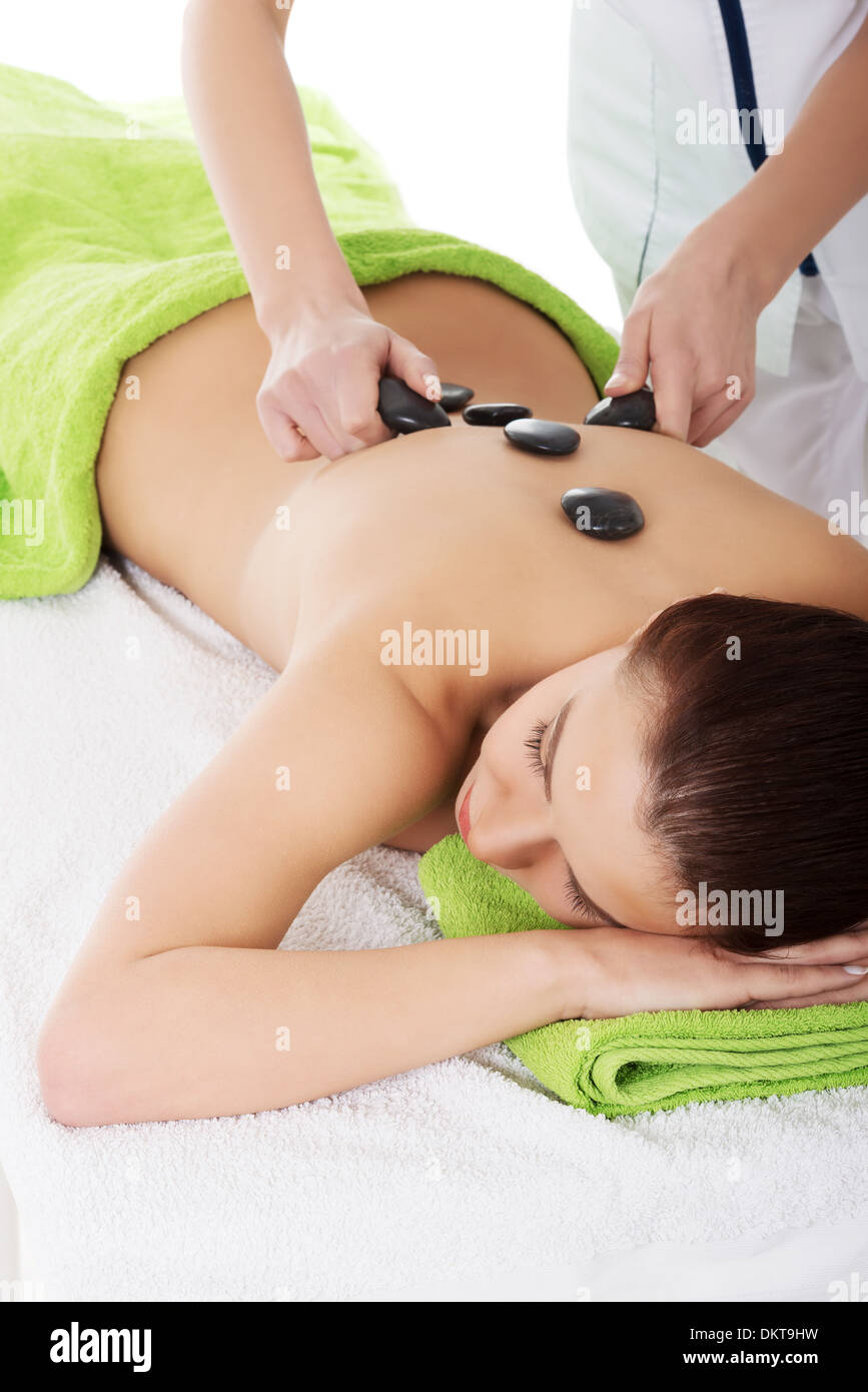 Bella donna sdraiata sulla spa salone avente stone massage. Concetto di Spa. Foto Stock