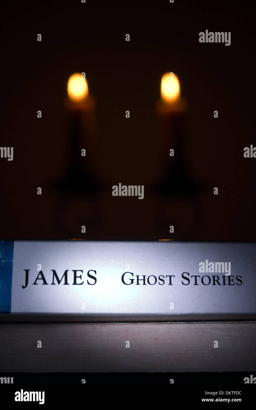 Libro di Ghost Stories per autore m.r.James, con candele Foto Stock