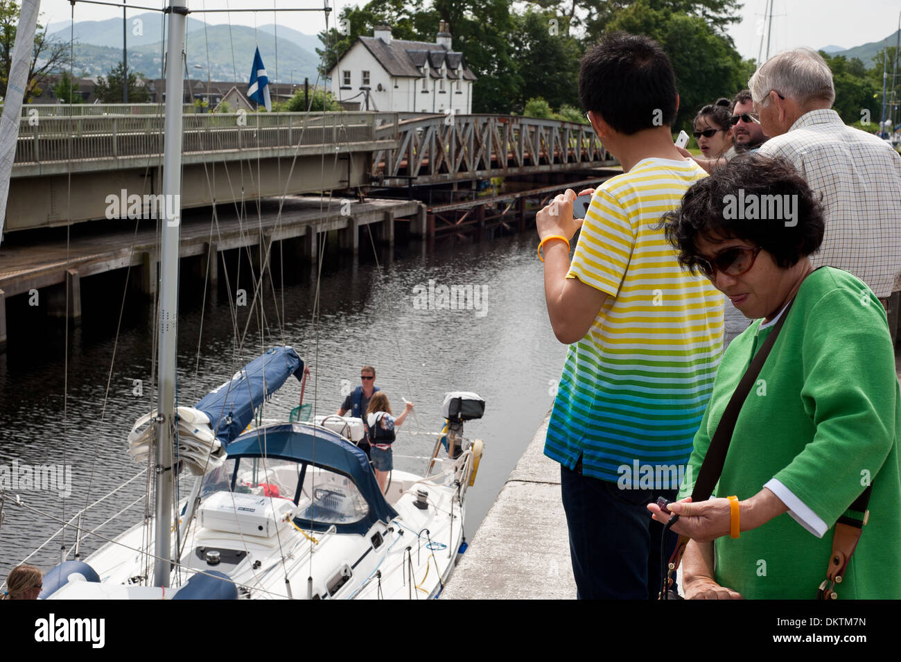 I turisti si riuniscono per guardare le barche a Nettuno scalinata del Caledonian canal Fort William Foto Stock