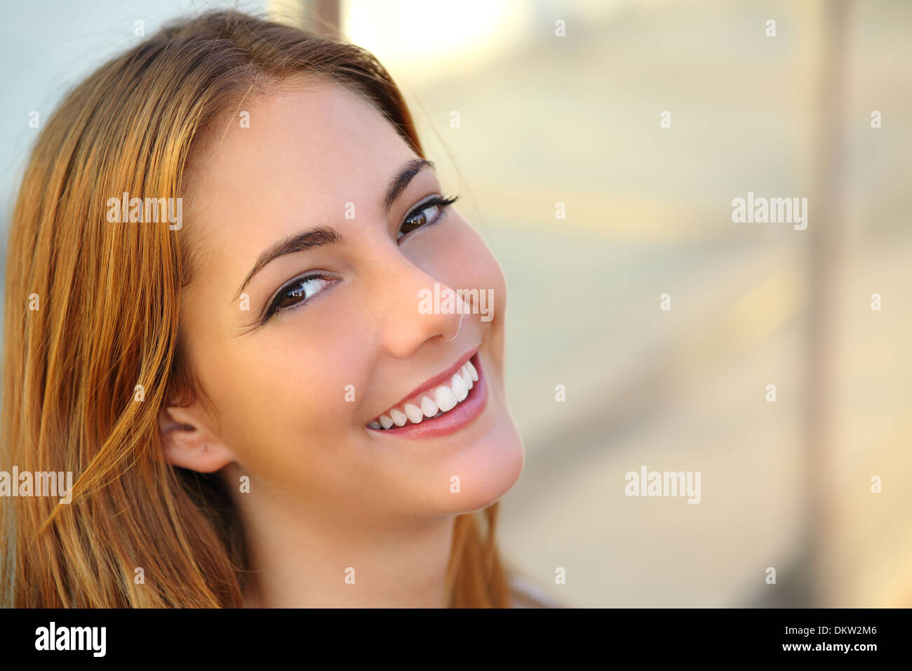 Bella donna con un bianco perfetto il sorriso e la pelle liscia con un background non focalizzato Foto Stock