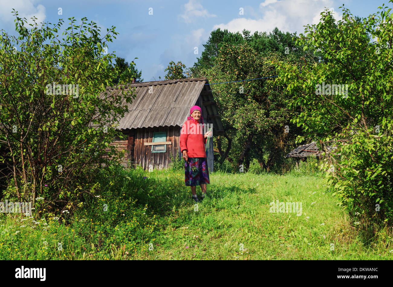 Stile di vita rurale 2013 - 6.La donna anziana il contadino si tiene in mano le cipolle raccolte su un orto. Foto Stock