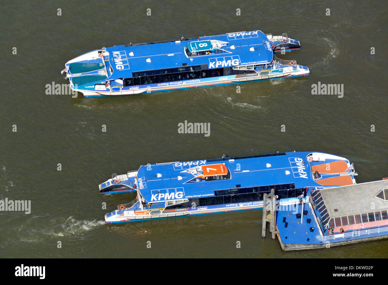 Guardando verso il basso dall'alto sopra il fiume Tamigi a due clipper acqua barche autobus accanto al Ponte di Londra City Pier Foto Stock