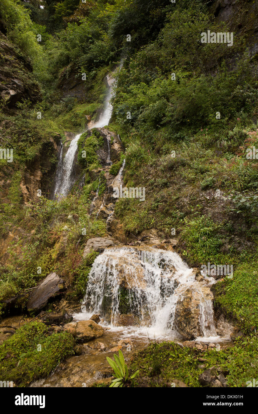 Il Bhutan, Trongsa, una piccola cascata tumbling down hillside Foto Stock