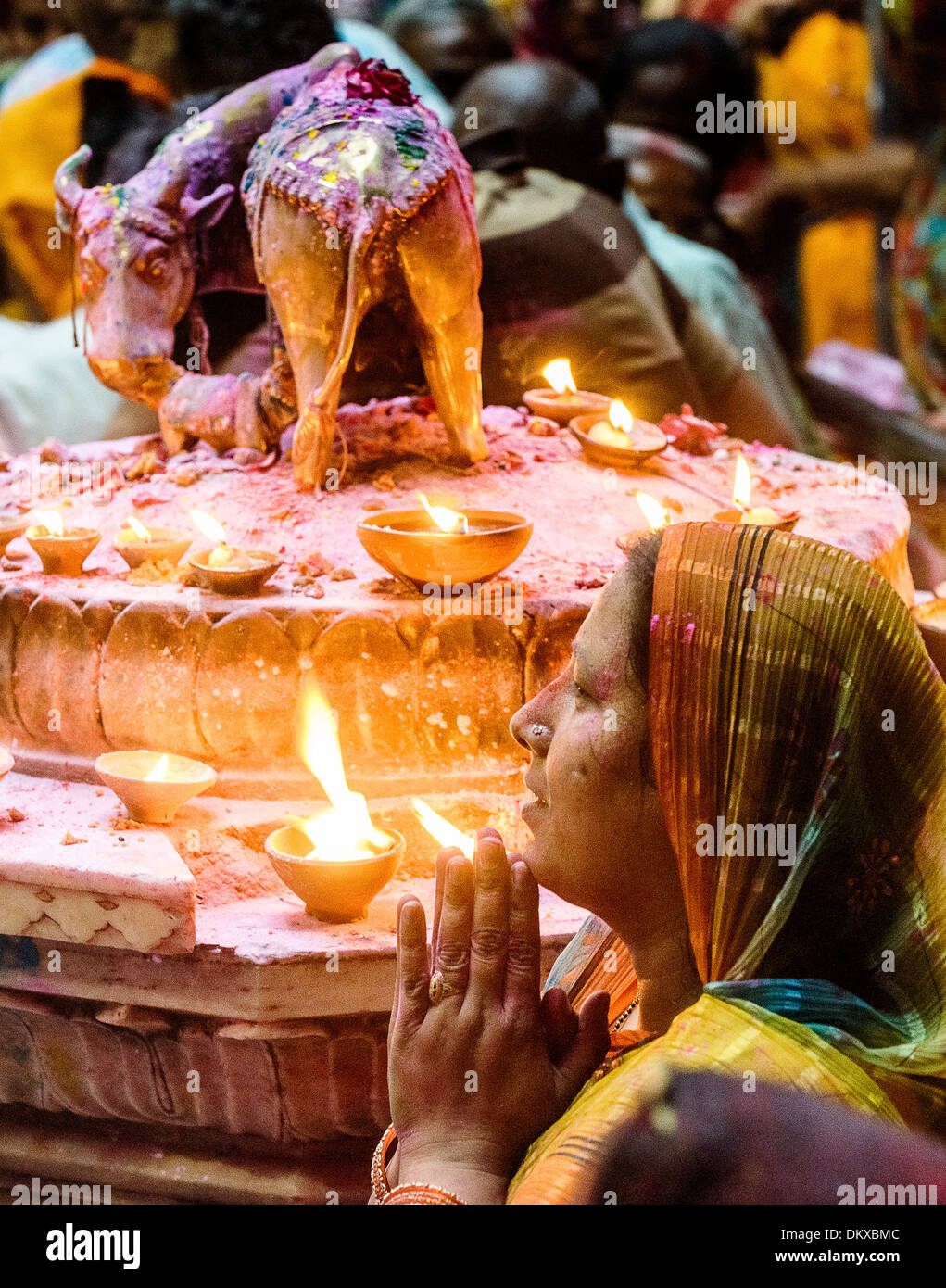 Donna indiana pregando durante Holi Bankey Bihari tempio, Vrindavan India Foto Stock