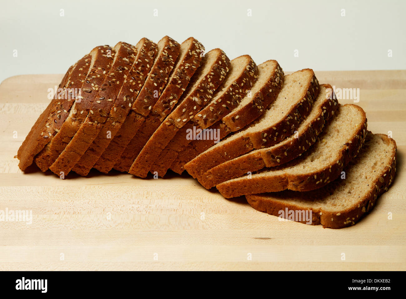 Un multiplo integrale di grano pagnotta di pane su un tagliere di legno Foto Stock