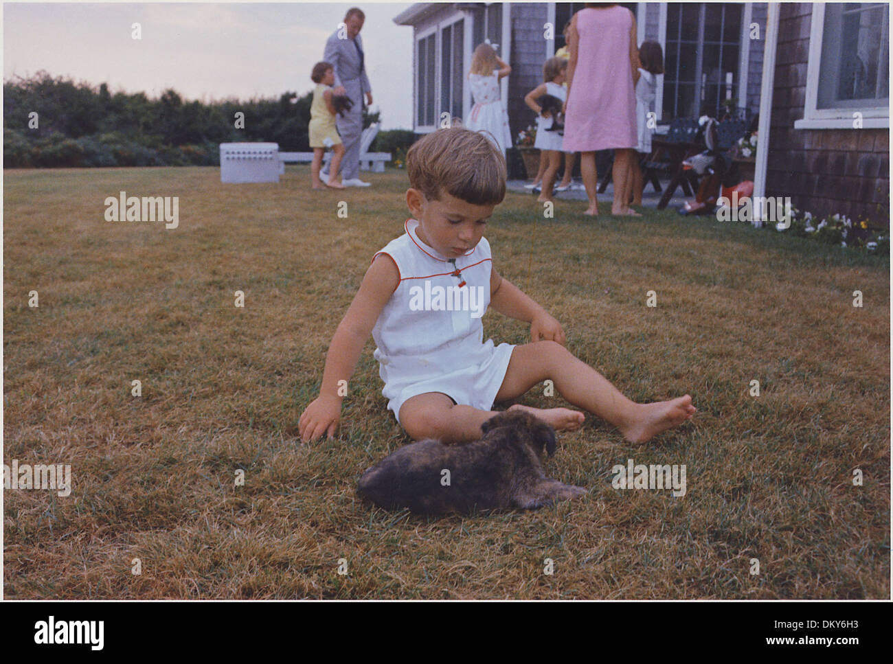 John F. Kennedy Jr. con cucciolo. Hyannisport, MA Squaw Island 194256 Foto Stock