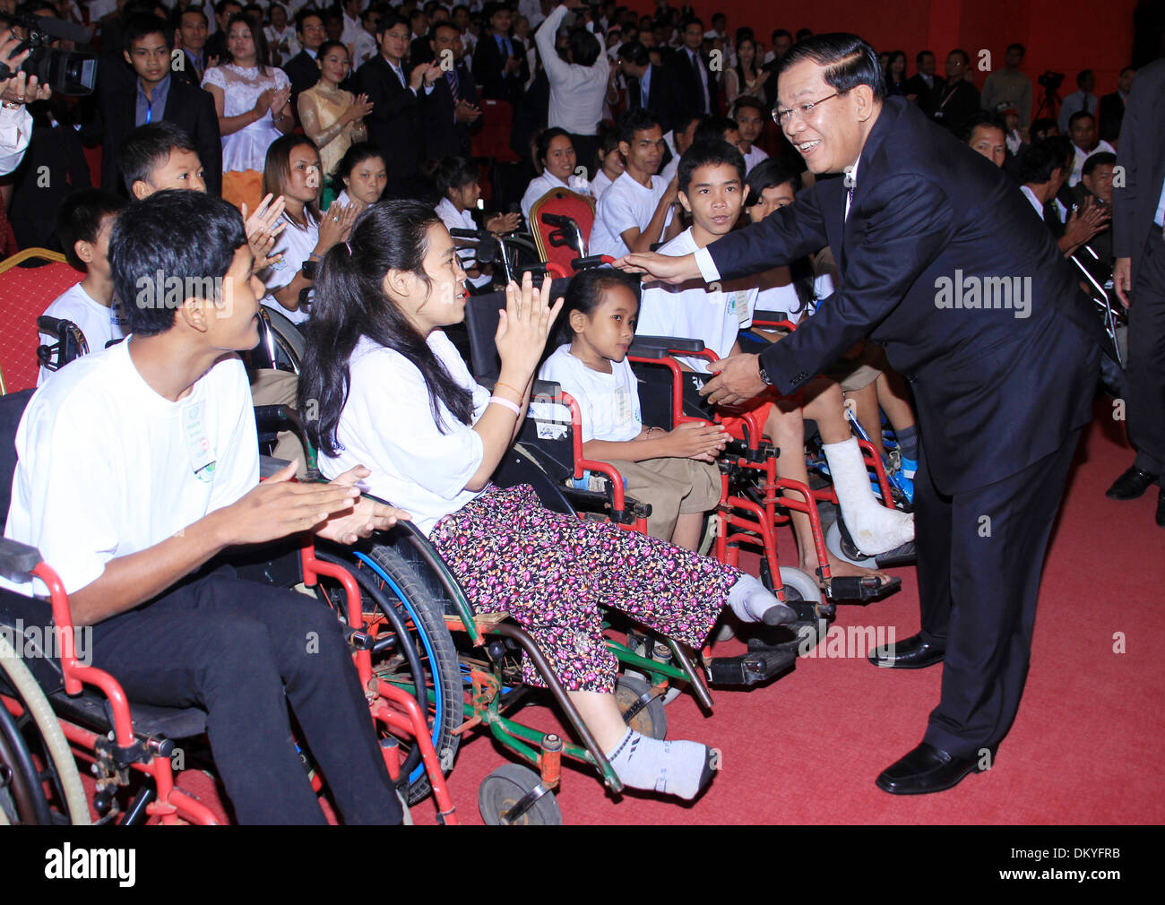 (131210) -- Phnom Penh, Dic 10, 2013 (Xinhua) -- Primo ministro cambogiano Hun Sen (R) anteriore incontra con le persone con disabilità in Phnom Penh Cambogia, Dic 10, 2013. Primo ministro cambogiano Hun Sen ha detto martedì che del paese le persone con disabilità hanno ancora di fronte un certo numero di sfide e il governo ha lavorato per la preparazione di un piano strategico quinquennale (2014-2018) al fine di migliorare il loro status sociale e mezzi di sostentamento. (Xinhua/Sovannara) Foto Stock