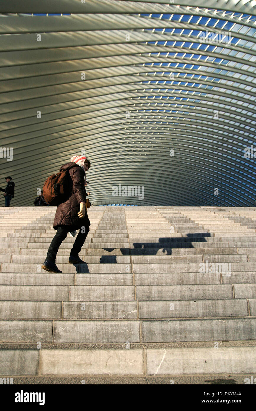 Scale e tetto con una giovane donna di arrampicata fino alla piattaforma in una stazione ferroviaria di Liegi, in Belgio. Foto Stock