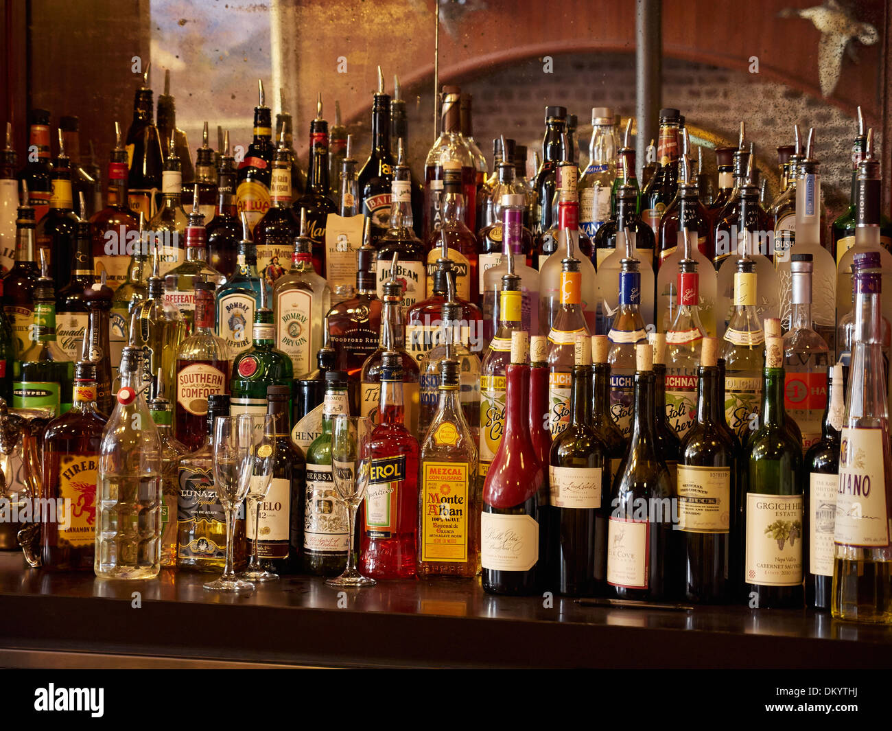 Bottiglie di liquore fissati dietro un bar Foto Stock
