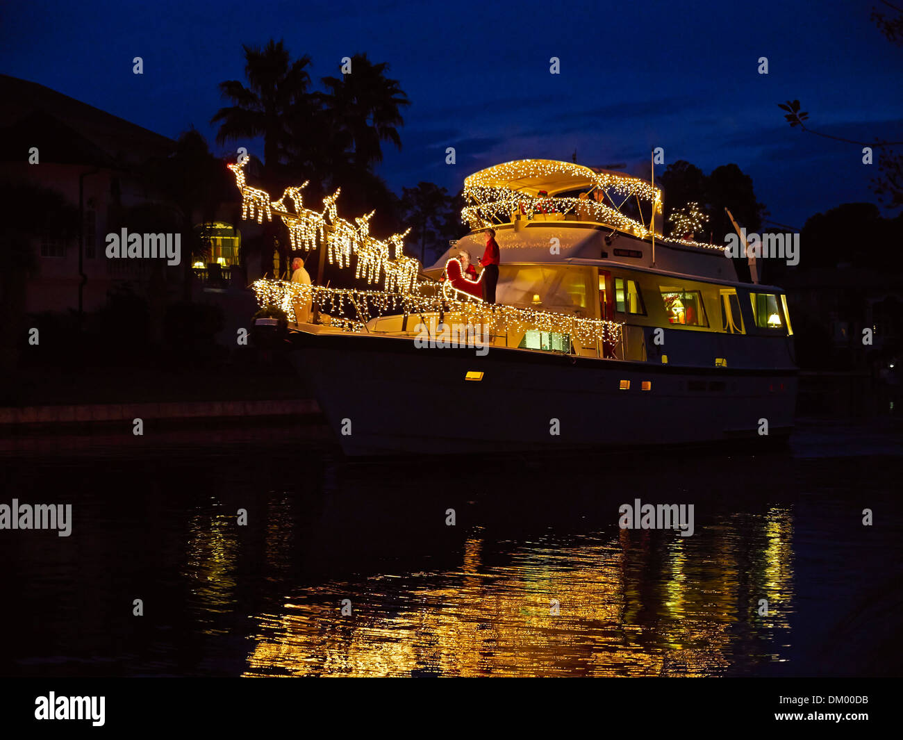 Le decorazioni di Natale su una barca in Carolina del Sud. Un grande yacht a motore è splendidamente decorato con luci bianche e renne. Foto Stock