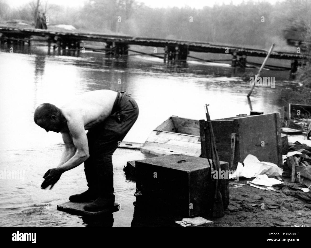Fine della guerra a Berlino nel 1945 - Un soldato si lava all'alba nel fiume Sprea, dopo aver messo da parte il fucile. Fotoarchiv für Zeitgeschichte Foto Stock