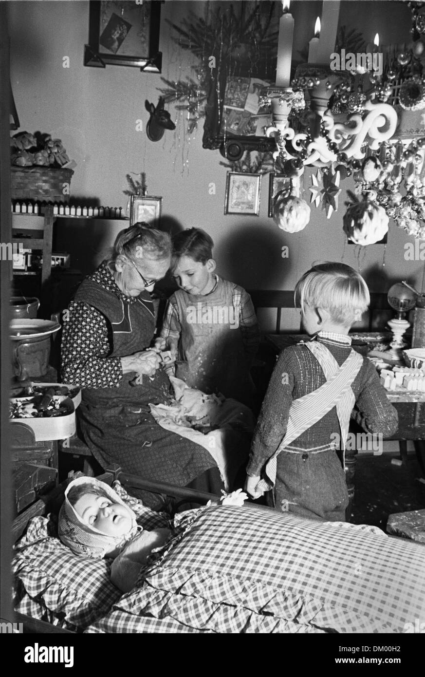 Una donna anziana è raffigurato con due bambini nel museo del giocattolo Seiffen nei monti Metalliferi prima di Natale non datato fotografia (1956). Foto: Deutsche Fotothek / Erich Höhne, Erich Pohl Foto Stock