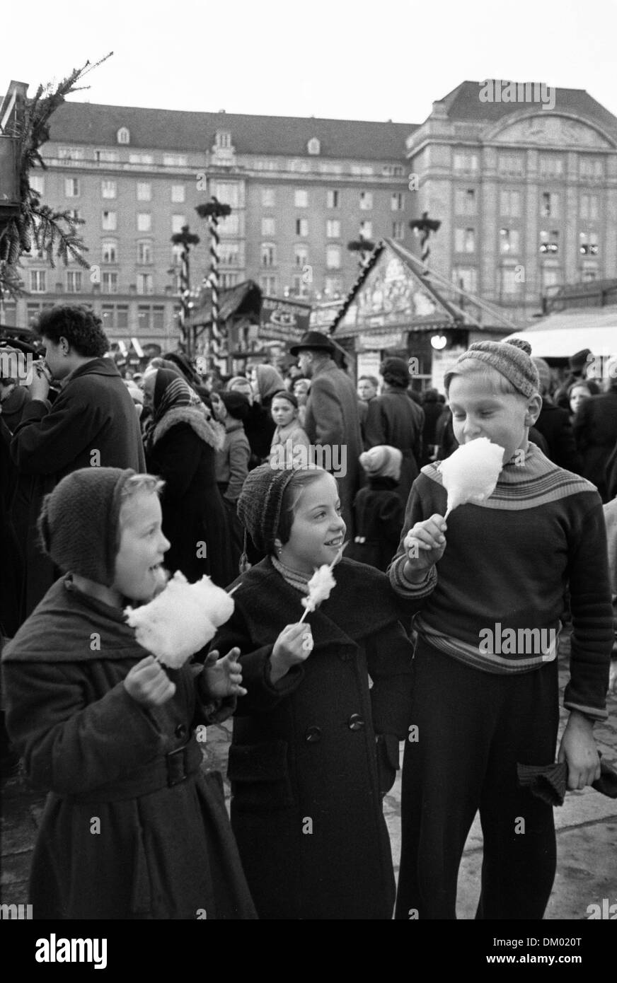 I bambini mangiano confetto al Striezelmarkt di Dresda, in Germania non datato fotografia (dicembre 1955). Foto: Deutsche Fotothek/Erich Höhne, Erich Pohl Foto Stock