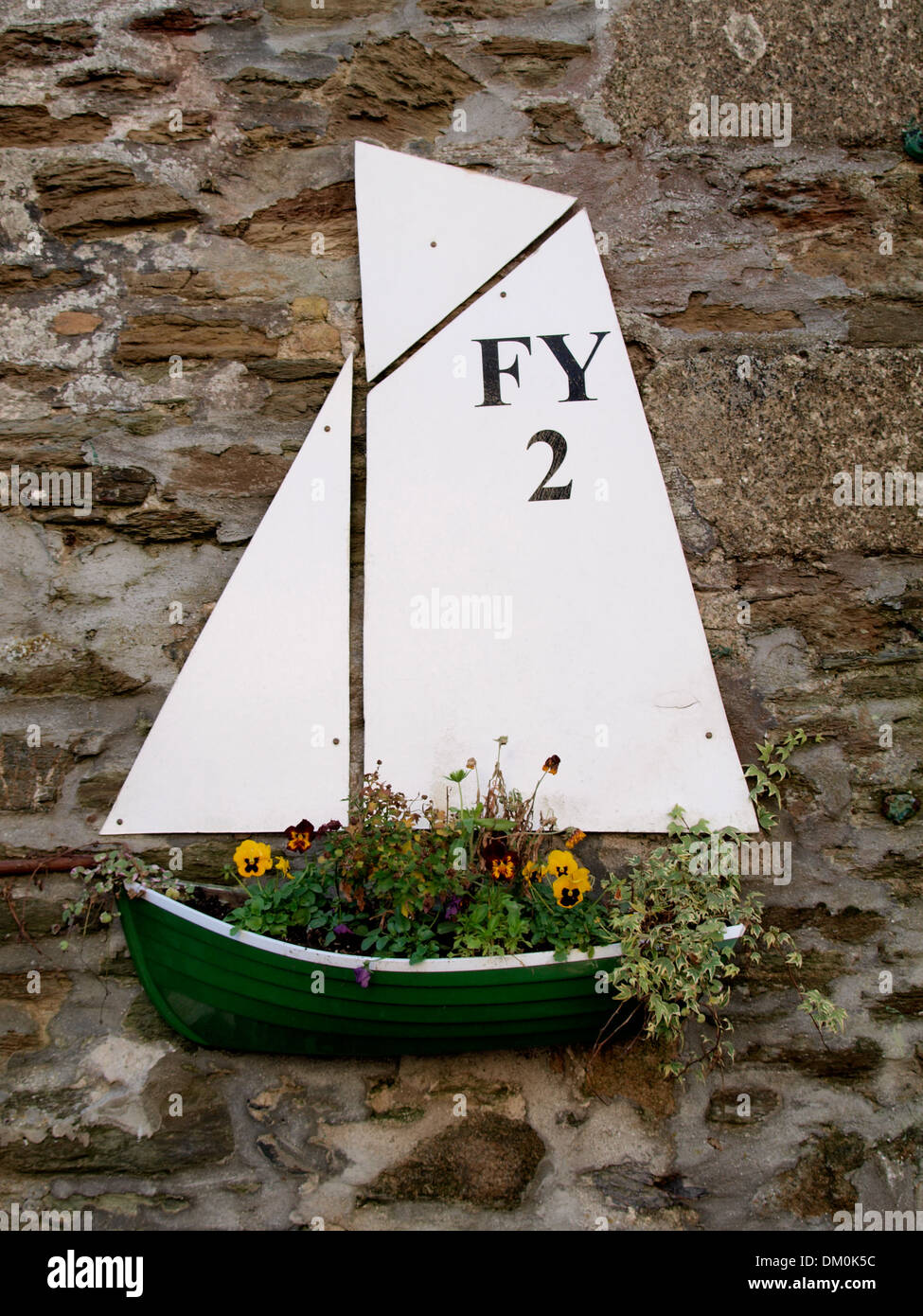Yacht fiore a forma di piantatrice attaccato ad un muro di casa, Fowey, Cornwall, Regno Unito Foto Stock