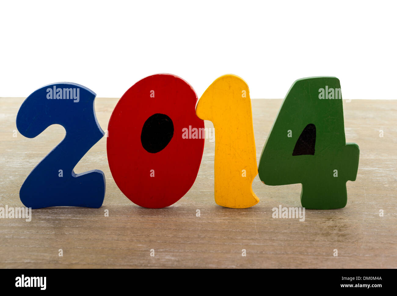 Il testo nuovo anno 2014 in lettere in legno blu rosso verde giallo sul piatto di legno Foto Stock