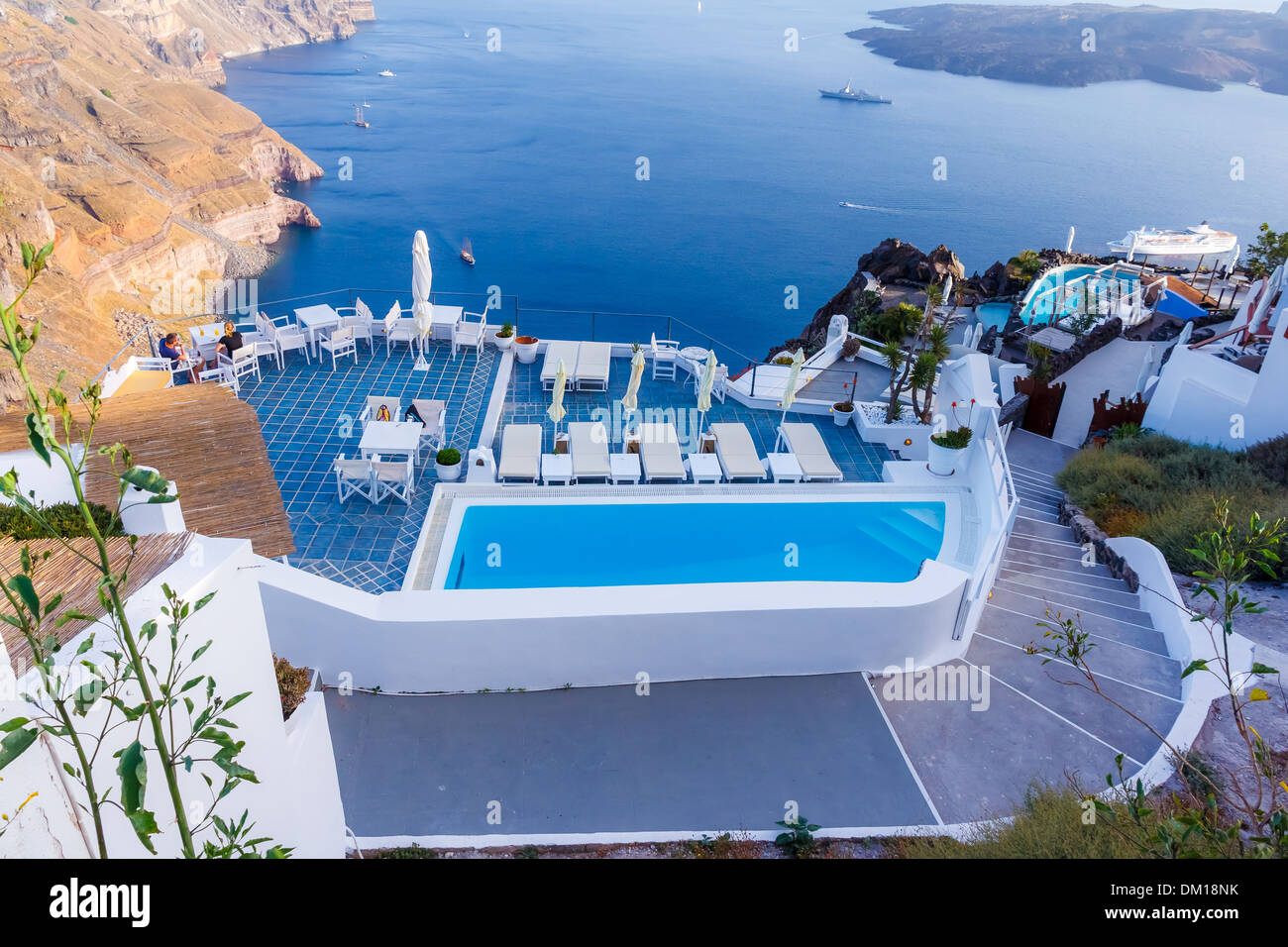 Lettini vicino alla piscina nel villaggio di Fira, Santorini, Grecia Foto Stock