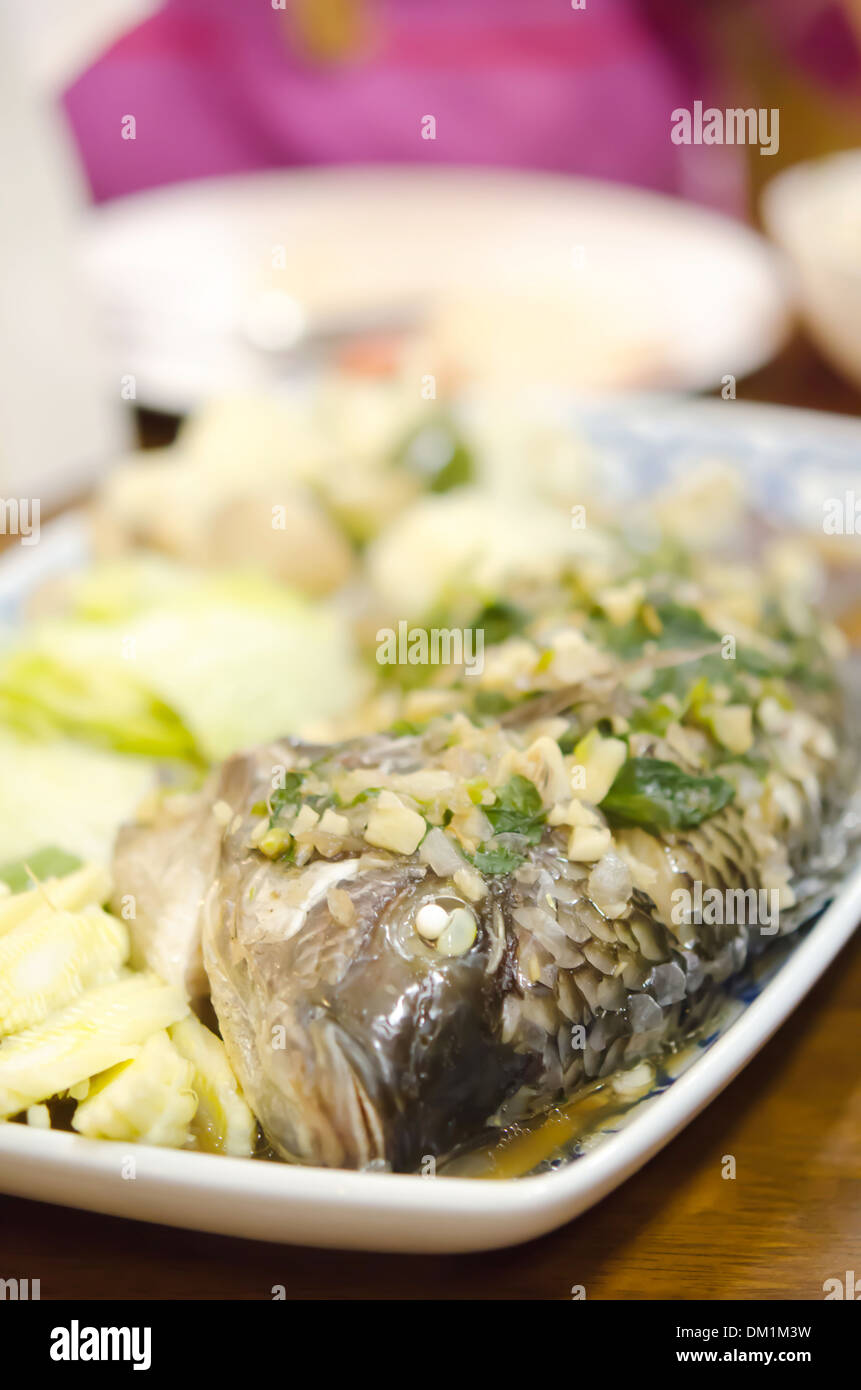 Pesce al vapore con aglio , erbe e verdure Foto Stock