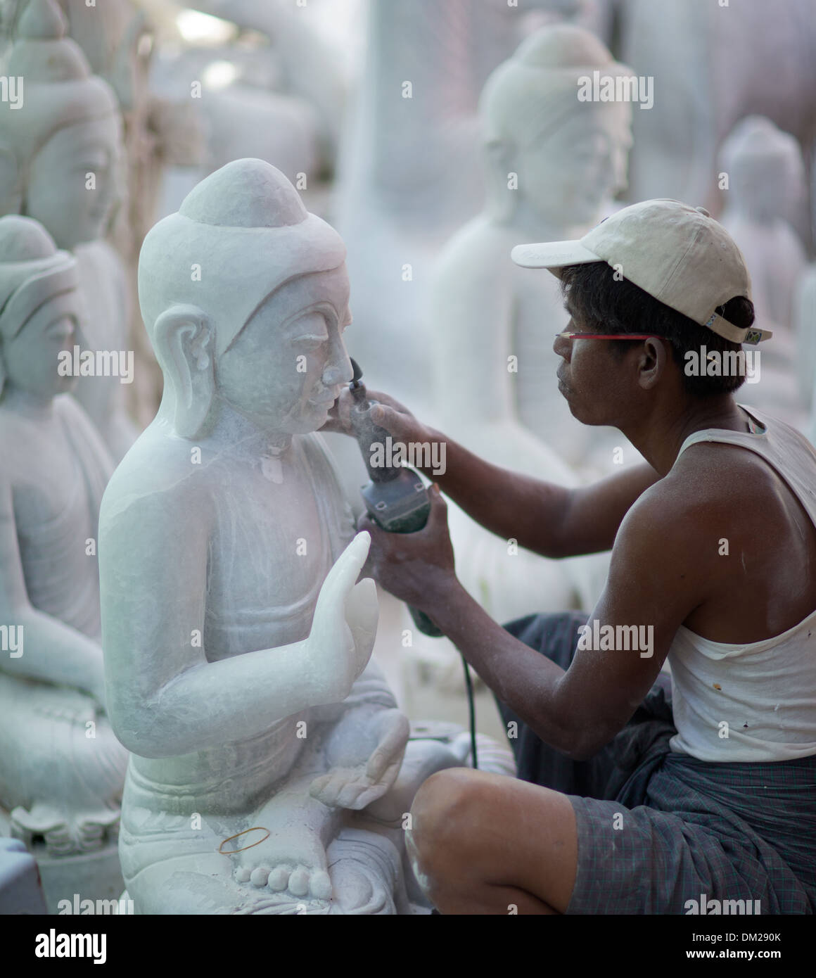 Una stone mason lavorando su marmo Buddha, Mandalay Myanmar (Birmania) Foto Stock