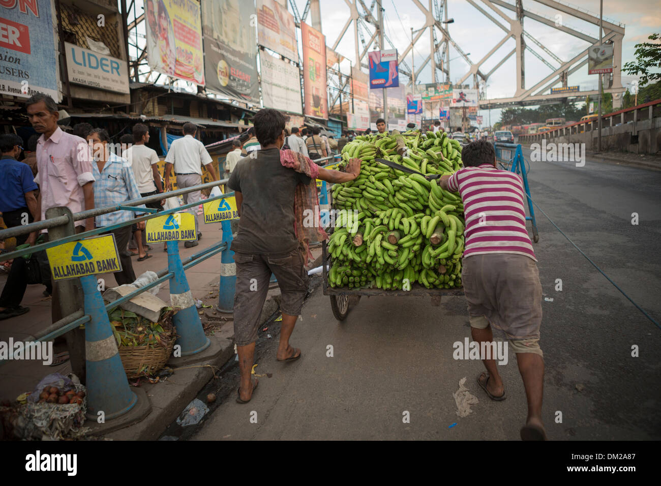 Street carrello pieno di banane attraversando il ponte di quella di Howrah a Calcutta (Kolkata), India Foto Stock