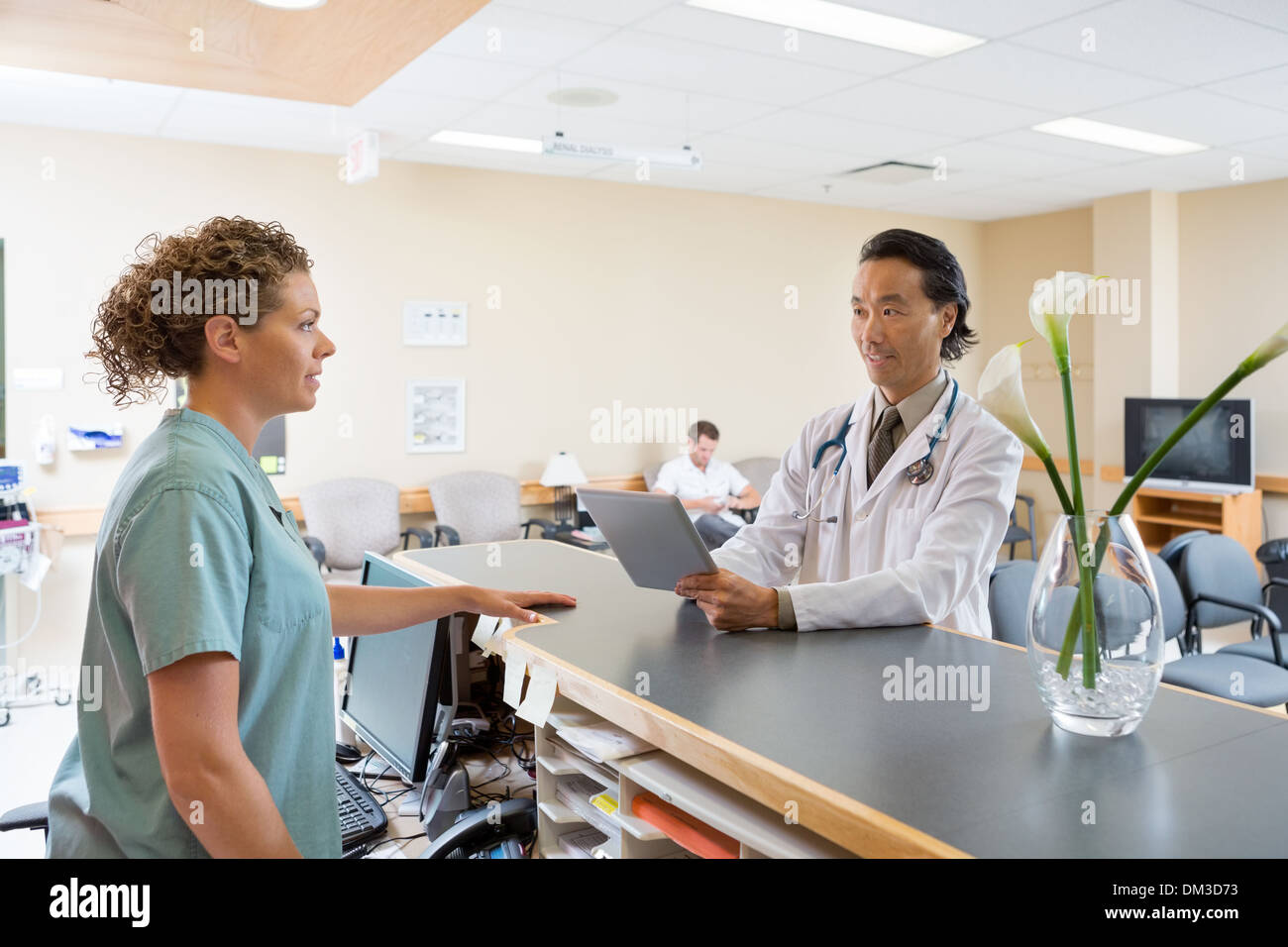 Infermiera e medico conversando al ricevimento dell'ospedale Foto Stock