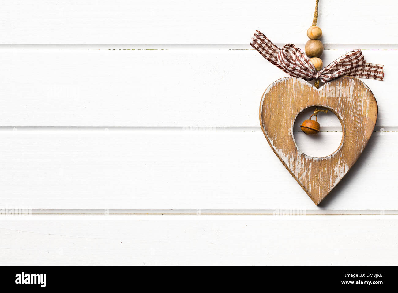 San Valentino in legno cuore appeso sul bianco sullo sfondo di legno Foto Stock