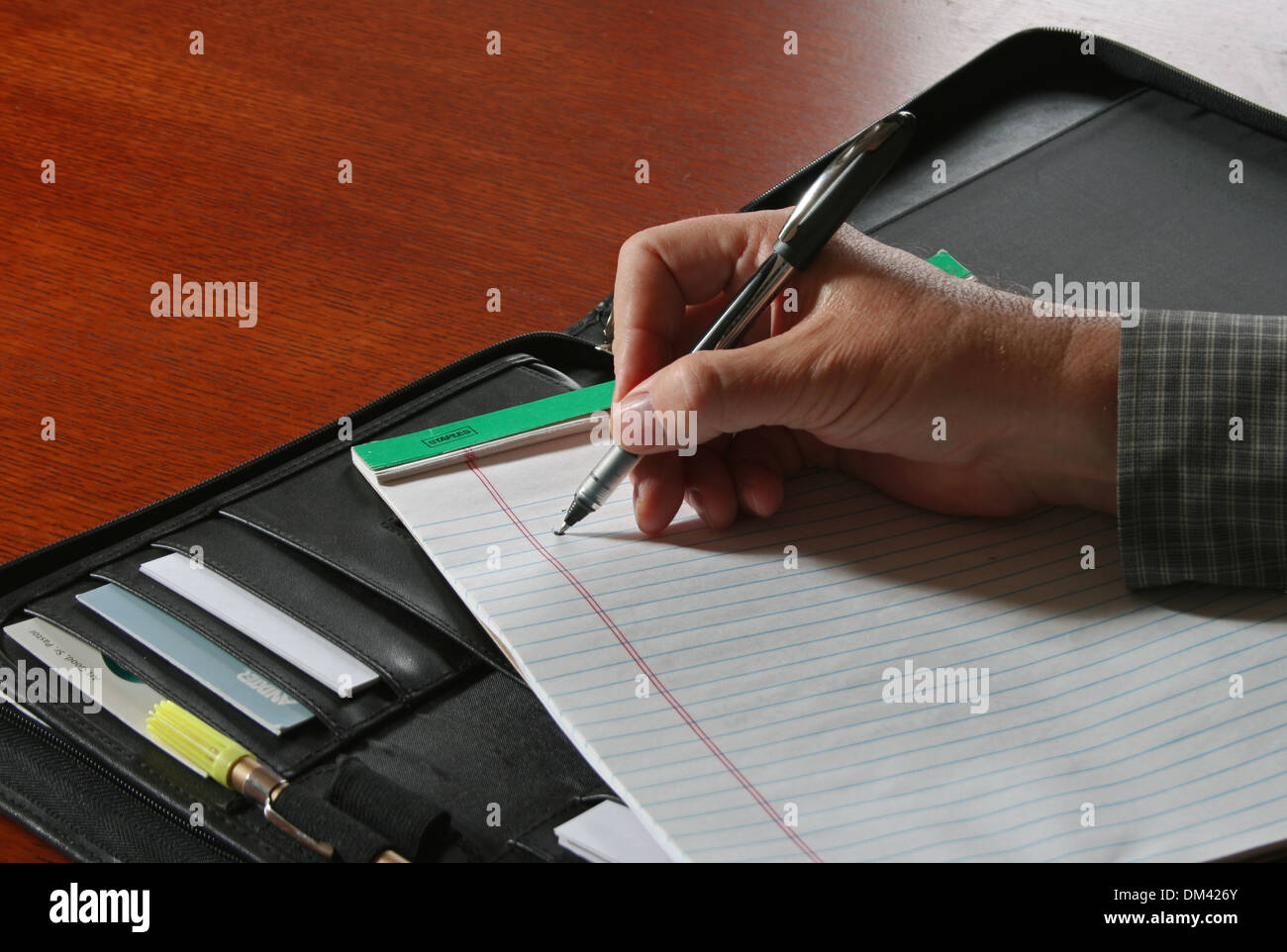 Imprenditore il la scrittura a mano su governata pad con il portafoglio Foto Stock