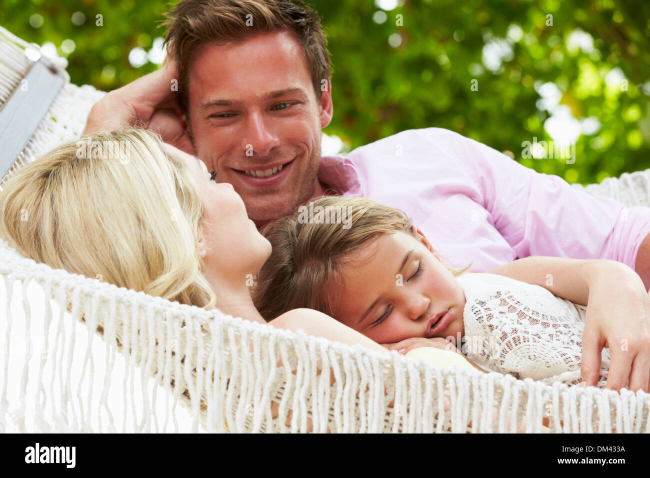 Famiglia relax in spiaggia con amaca Sleeping figlia Foto Stock