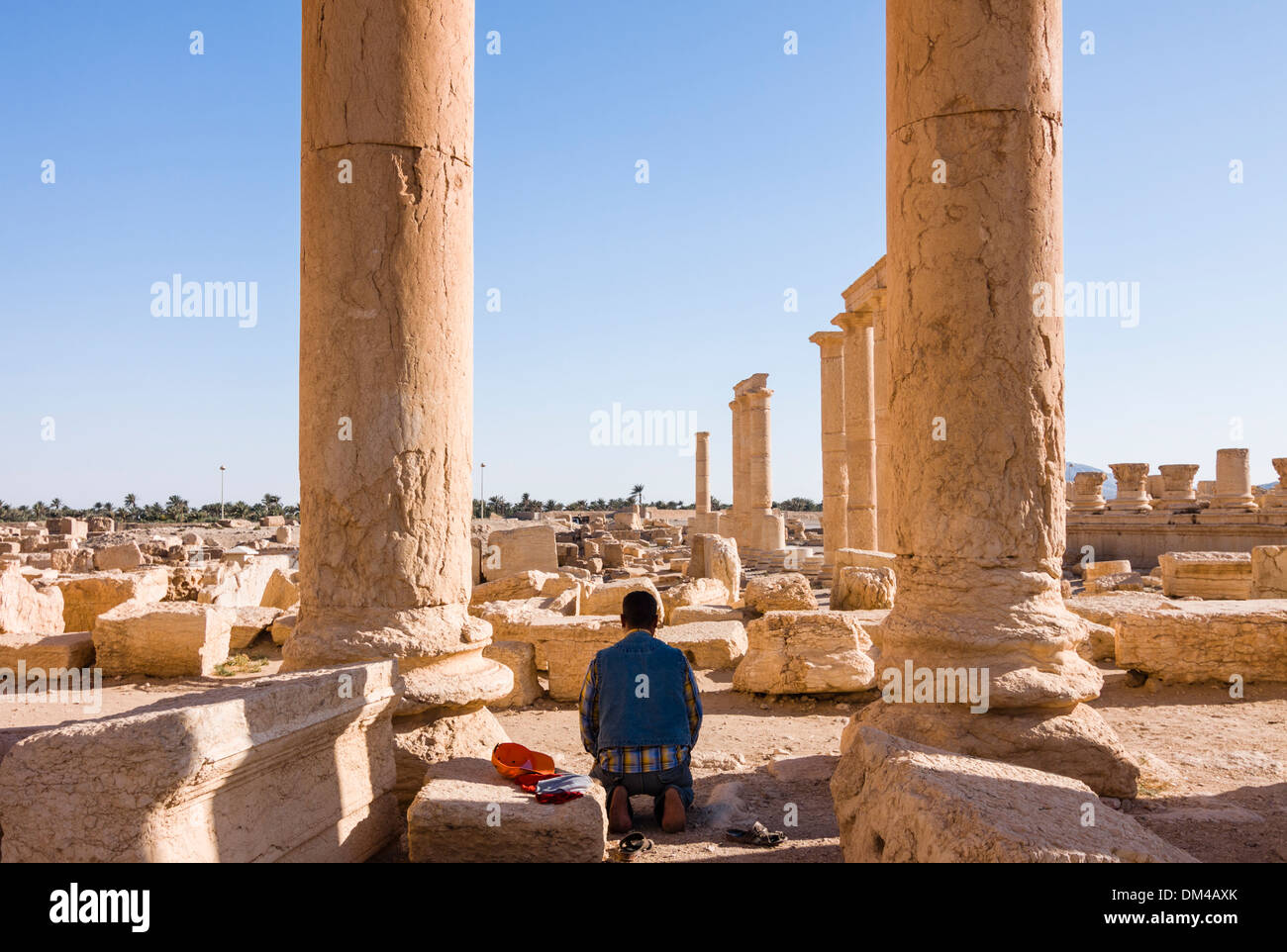 Uomo musulmano di pregare presso le rovine di Palmyra, Siria Foto Stock