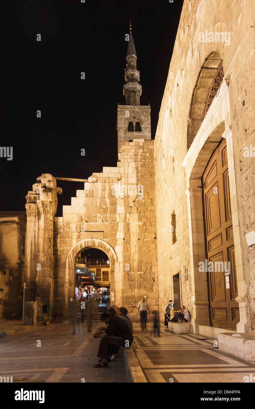 Gli uomini seduti durante la notte presso la porta posteriore della moschea omayyade a Damasco, Siria Foto Stock