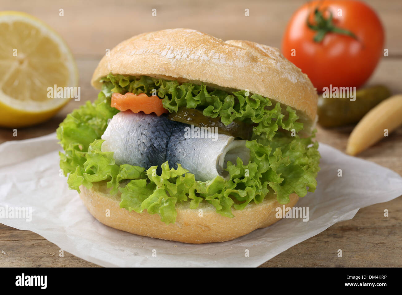 Un panino con aringa serviti con un pomodoro Foto Stock
