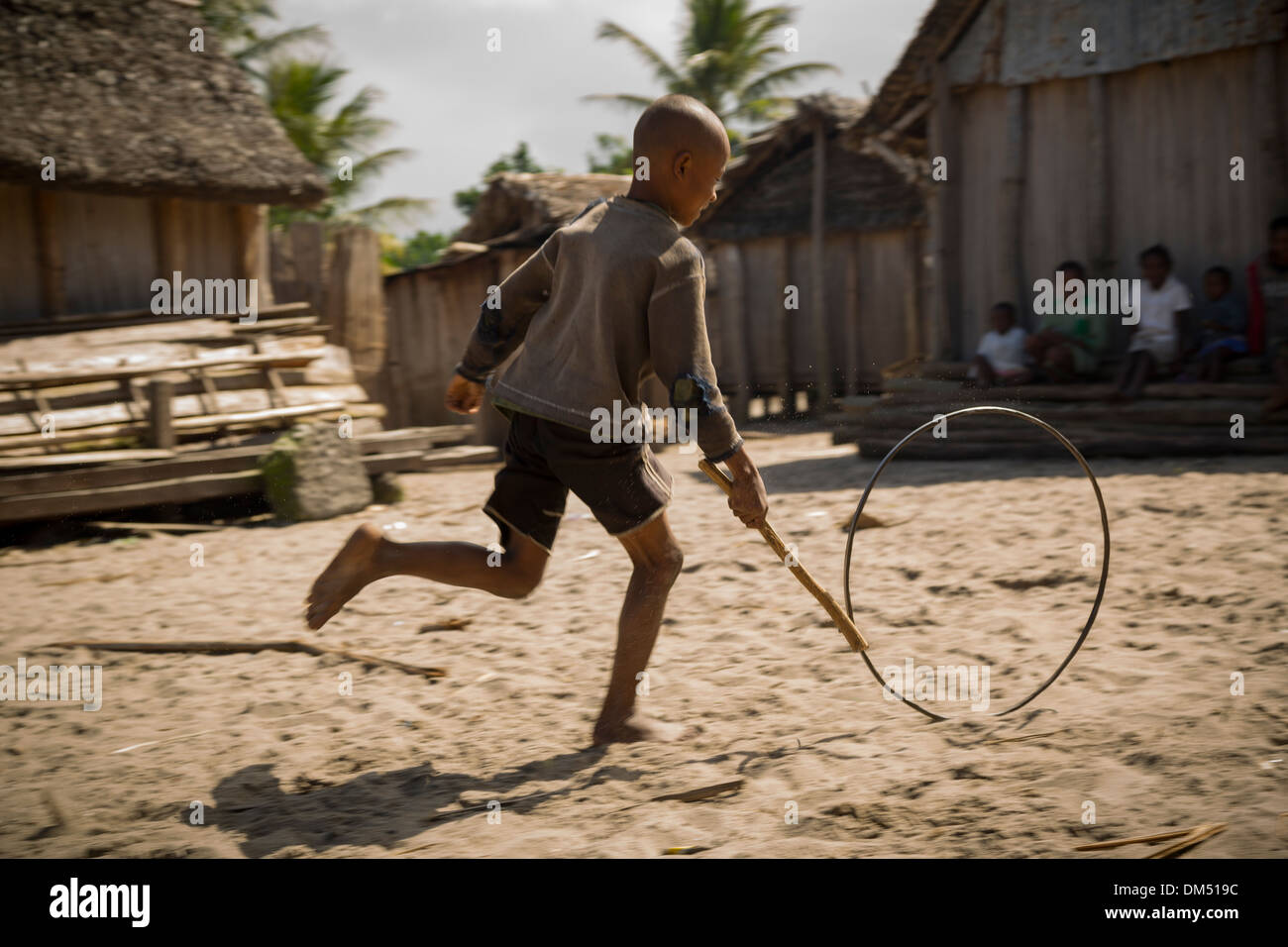 Un bambino che gioca con una ruota in Vatomandry distretto, Madagascar. Foto Stock
