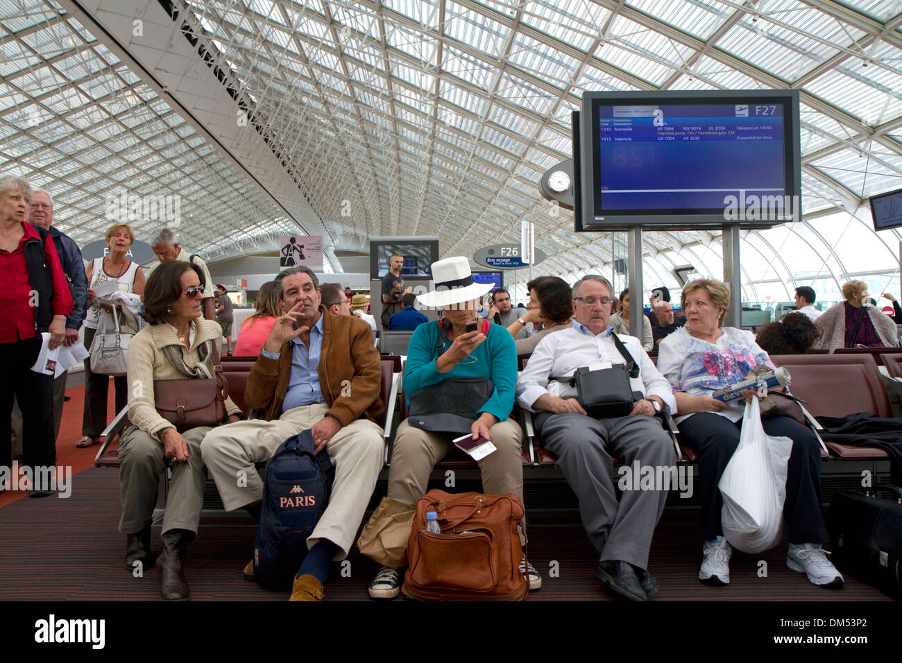 I viaggiatori in una sala di attesa all'Aeroporto Charles de Gaulle di Parigi, Francia. Foto Stock