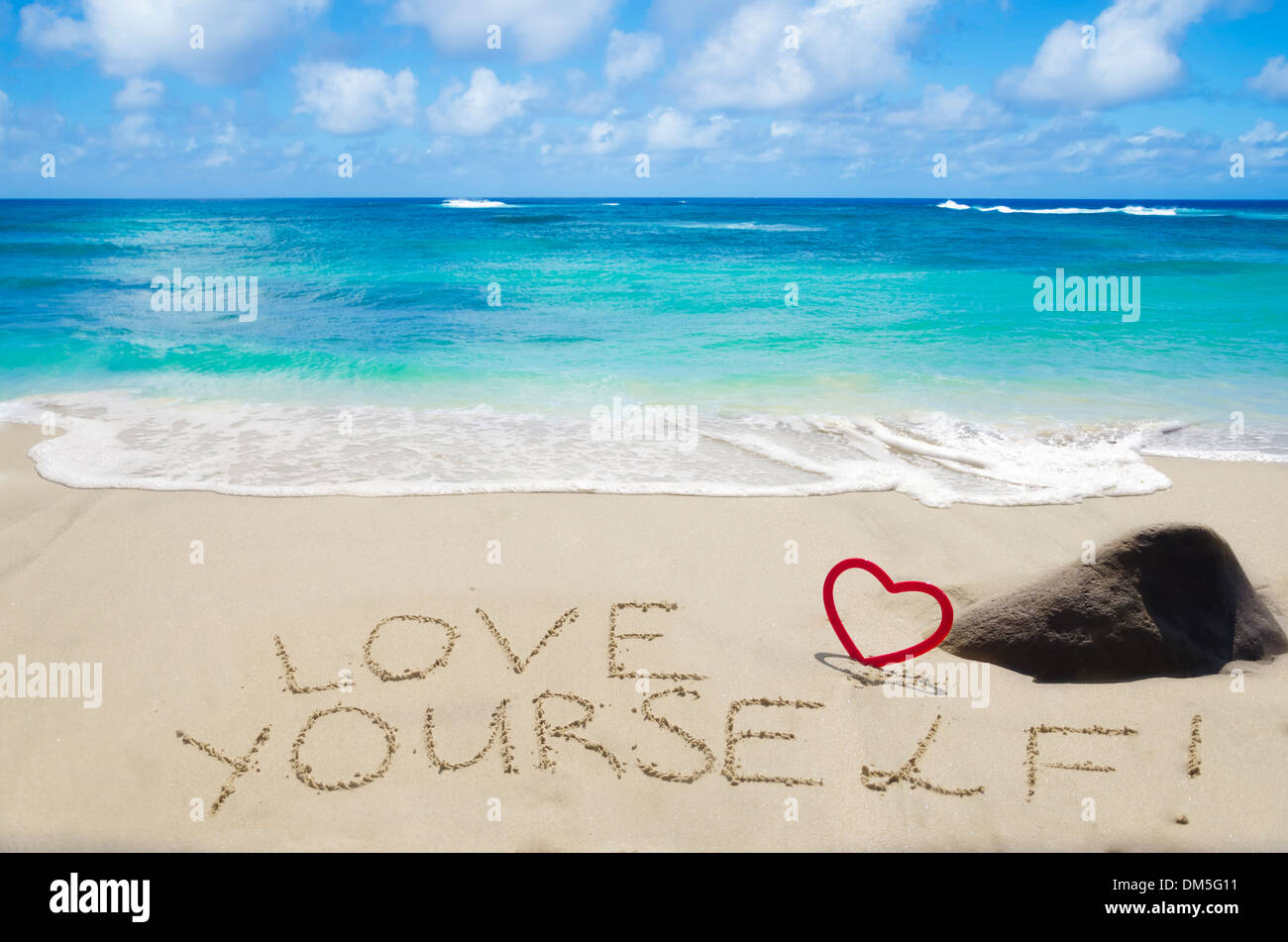 Segno "l'amore di te' con cuore sulla spiaggia sabbiosa dall'oceano Foto Stock