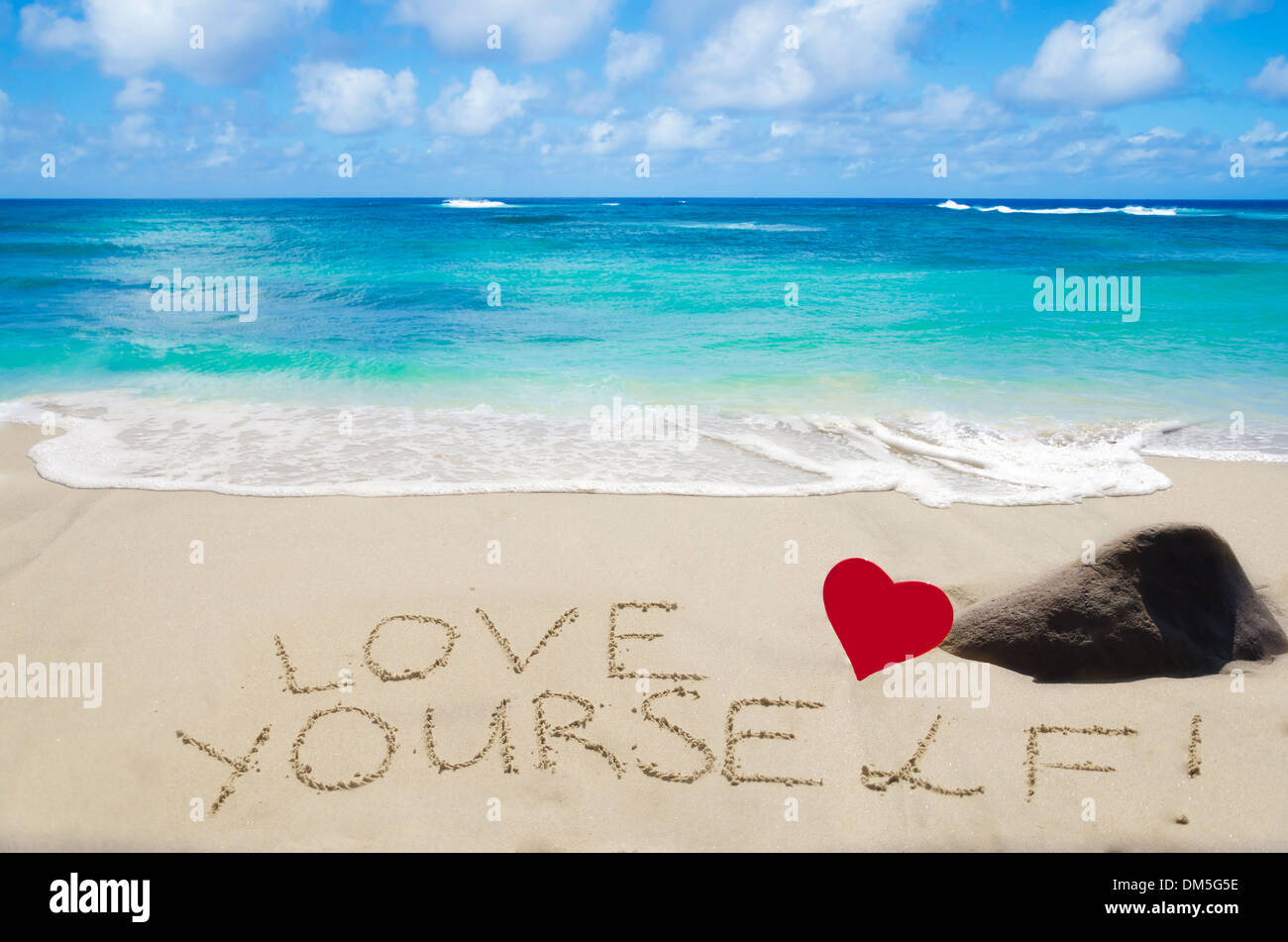 Segno "l'amore di te' con cuore sulla spiaggia sabbiosa dall'oceano Foto Stock