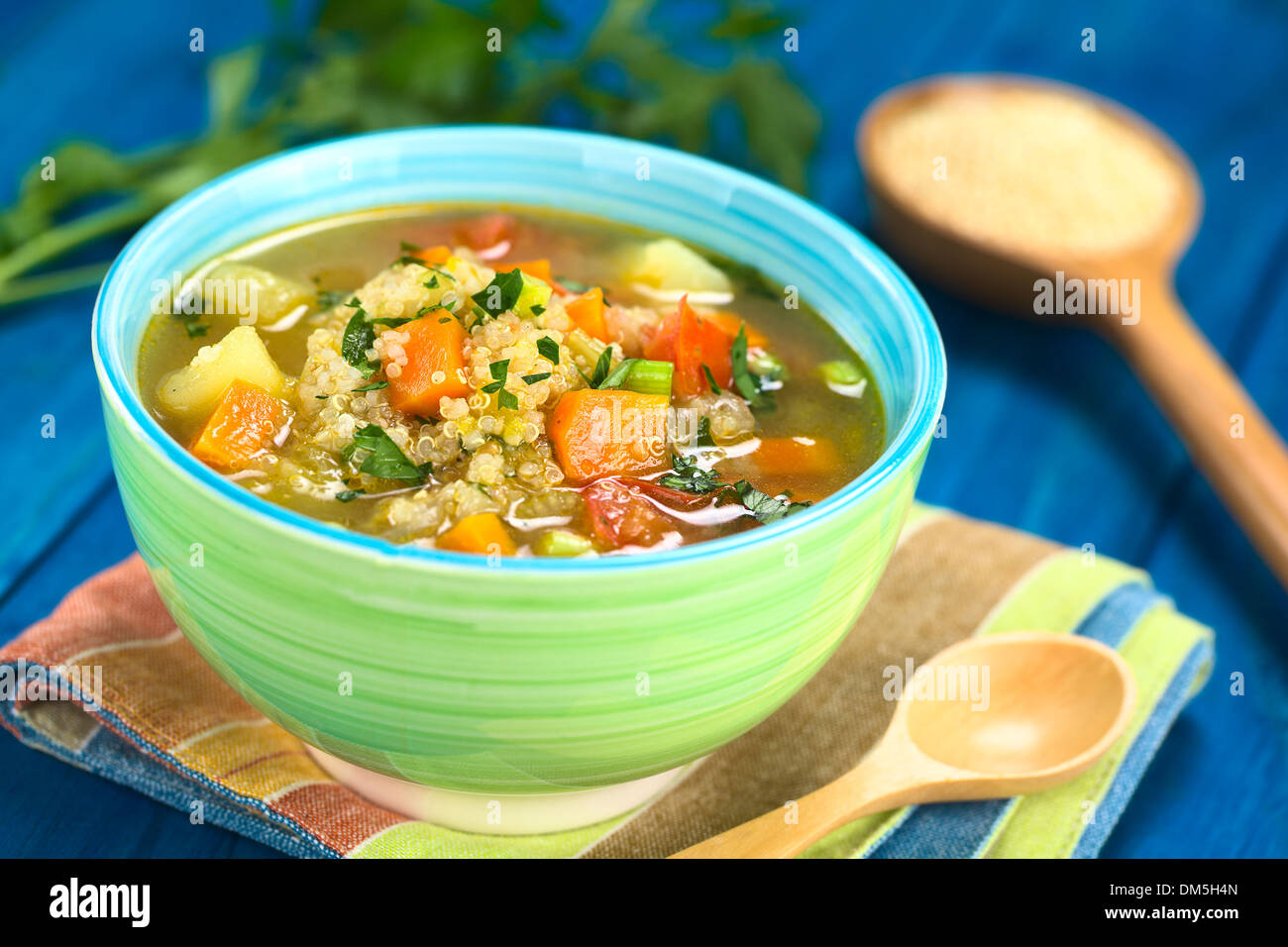 Quinoa vegetariano zuppa con carote, patate, porri e pomodoro, cosparsa di prezzemolo e scalogno in vaso colorato Foto Stock