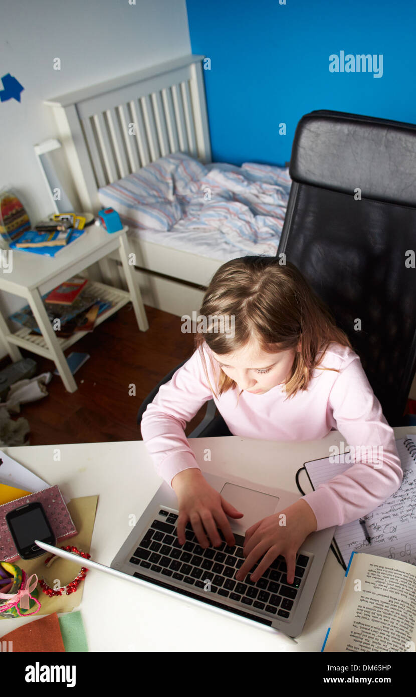 Ragazza che studiano in camera da letto utilizzando Laptop Foto Stock