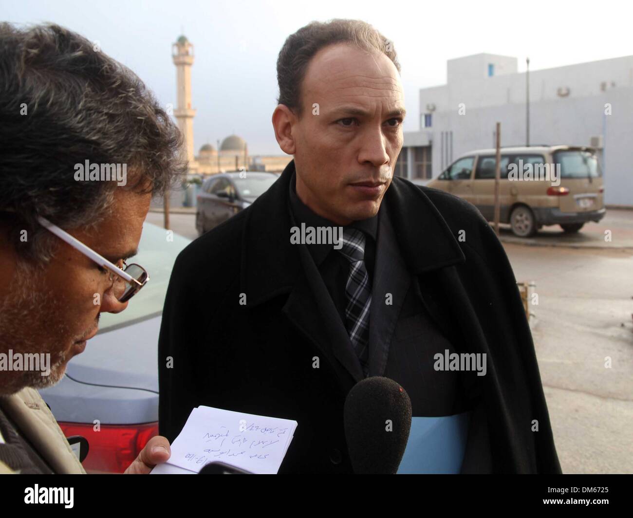 Zintan, Libia. 12 Dic, 2013. Seif al-Islam suo aspetto in corte di Tripoli. Mohammed Busema (R), la Corte-rappresentante legale designato per l'audizione su oneri di minacciare la sicurezza nazionale del Seif al-Islam, il secondo figlio dell ex leader libico Muammar Gheddafi, parla prima di Seif's aspetto in tribunale in Zintan, Libia. 12 Dic, 2013. Libia il 12 dicembre, 2013. La versione di prova audizione durò solo cinque minuti ed è stato aggiornato al 27 febbraio 2014 a causa della mancanza di altri accusati. Credito: Hamza Turkia/Xinhua/Alamy Live News Foto Stock