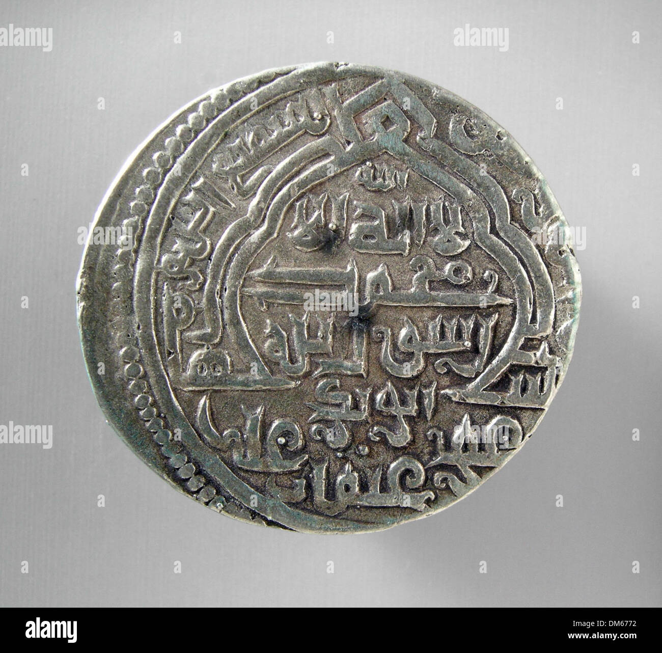 Questo dirham d'argento dell'Ilkhanide, una moneta dal XIII al XIV secolo, dimostra l'intricata maestria artigianale e l'iconografia associata al periodo dell'Ilkhanato in Persia. Foto Stock