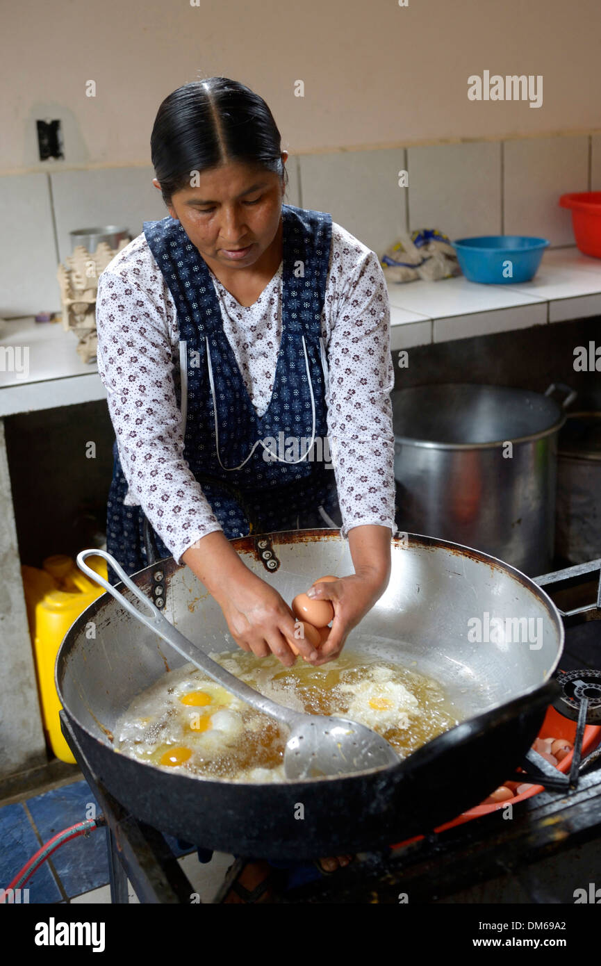Scuola di cucina, cuoco preparare uova fritte, Carmen Pampa, Yungas, Dipartimento di La Paz in Bolivia Foto Stock