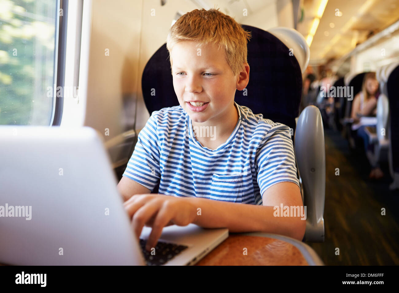 Boy utilizzando laptop in viaggio in treno Foto Stock