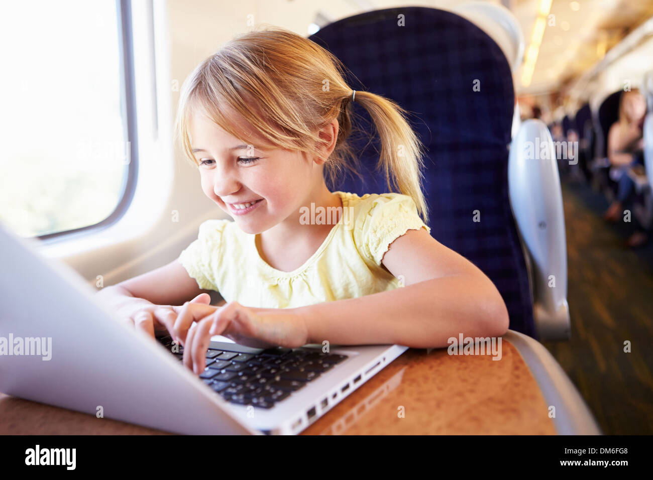 Ragazza utilizzando laptop sul treno Foto Stock