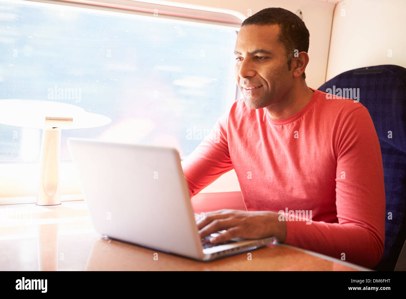 Uomo che utilizza sul computer portatile sul treno Foto Stock