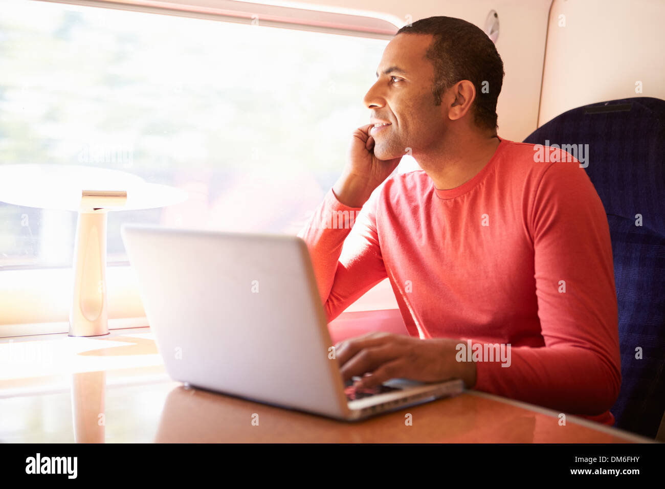 Uomo che utilizza sul computer portatile sul treno Foto Stock