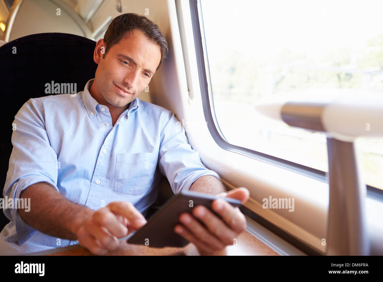 L uomo e la lettura di un libro sul treno Foto Stock