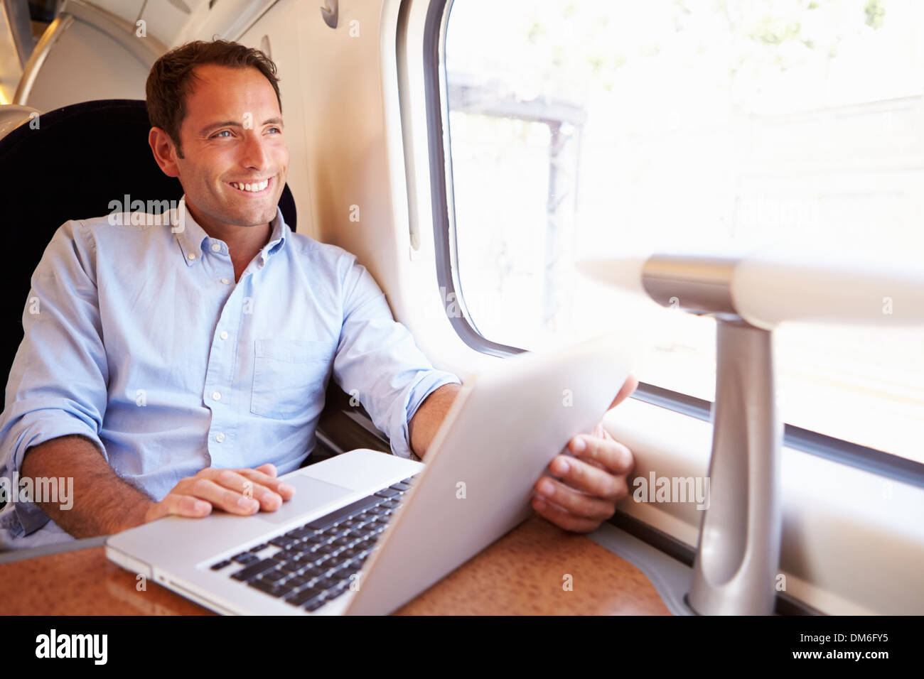 Uomo che utilizza sul computer portatile sul treno Foto Stock