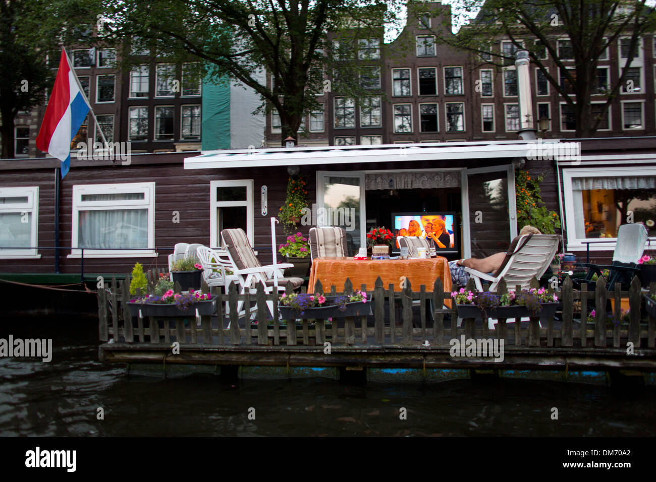 La donna a guardare la TV in una casa galleggiante ad Amsterdam Foto Stock