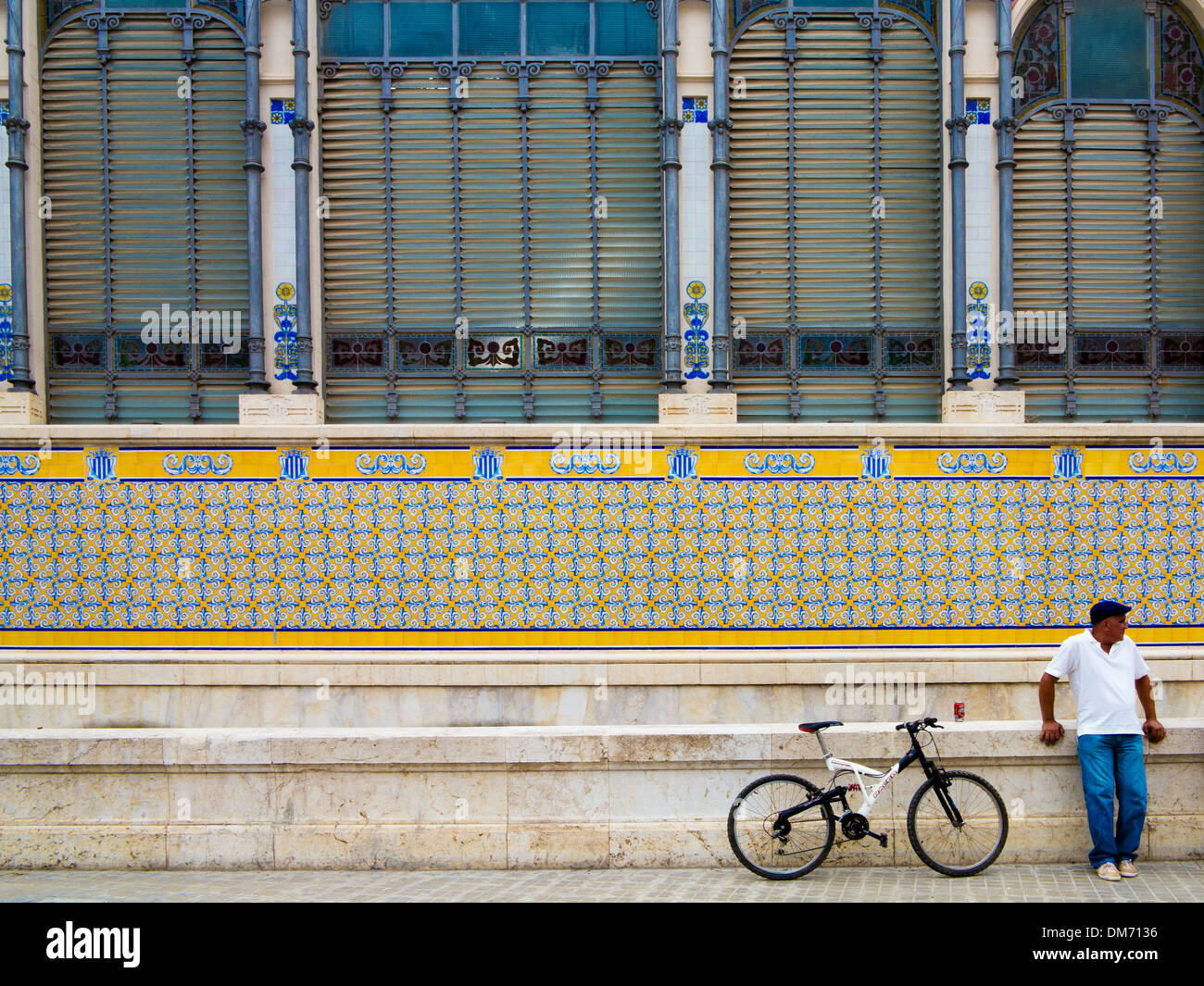 L'uomo con la bici si erge al di fuori del Mercado Central - mercato centrale di Valencia, Spagna. Foto Stock